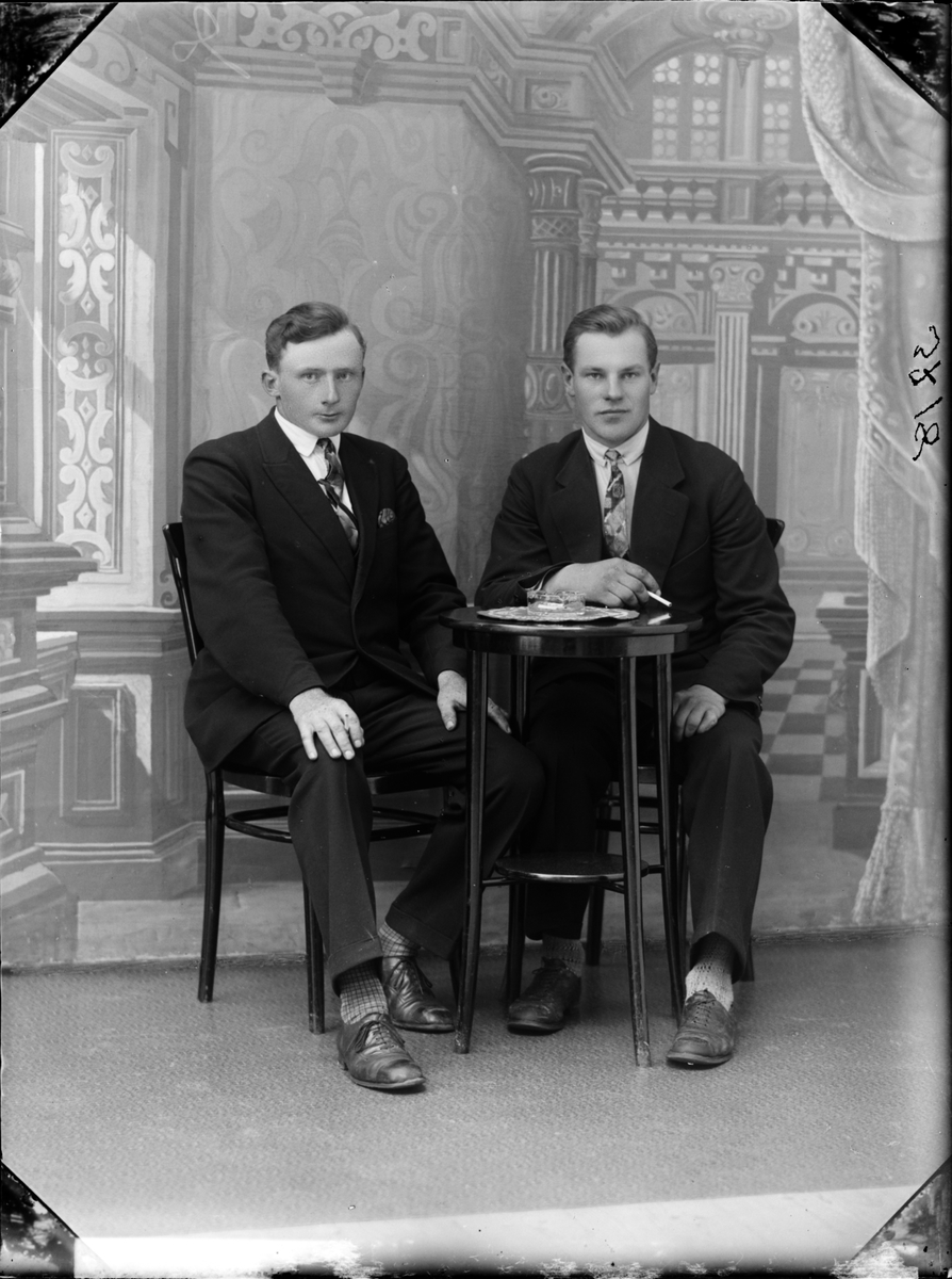 Två män sittande vid ett bord, Östhammar, Uppland