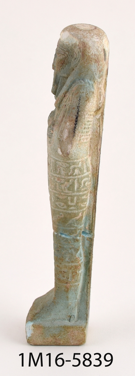 Statyett föreställande faraon med hieroglyfer i beige-grön sten.