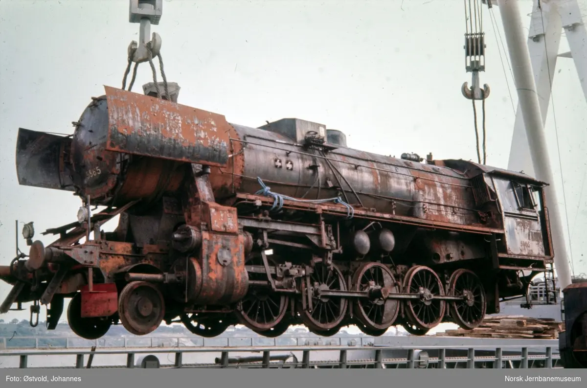 Damplokomotiv type 63a nr. nr. 5865 heises ombort i MS Stokksund og er under transport til England. Lokomotivet har stått hensatt som beredskapslok i en tunnel i Drangsdalen mellom Moi og Heskestad stasjoner.