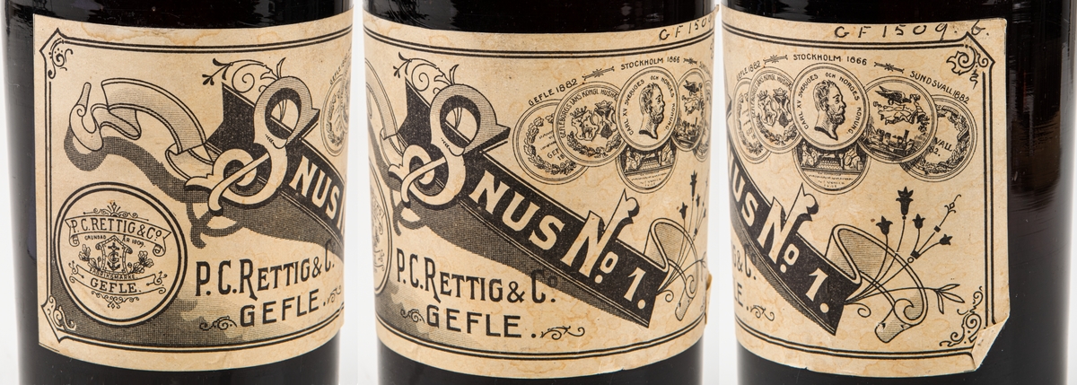 Snusflaska, mörkbrun flaska med ganska vid hals med kork. Etikett: "Snus nr 1, P.C. Rettig & Co, Gefle". Guldmedalj 1882 Gefle, 1866, Stockholm, 1882 Sundsvall.