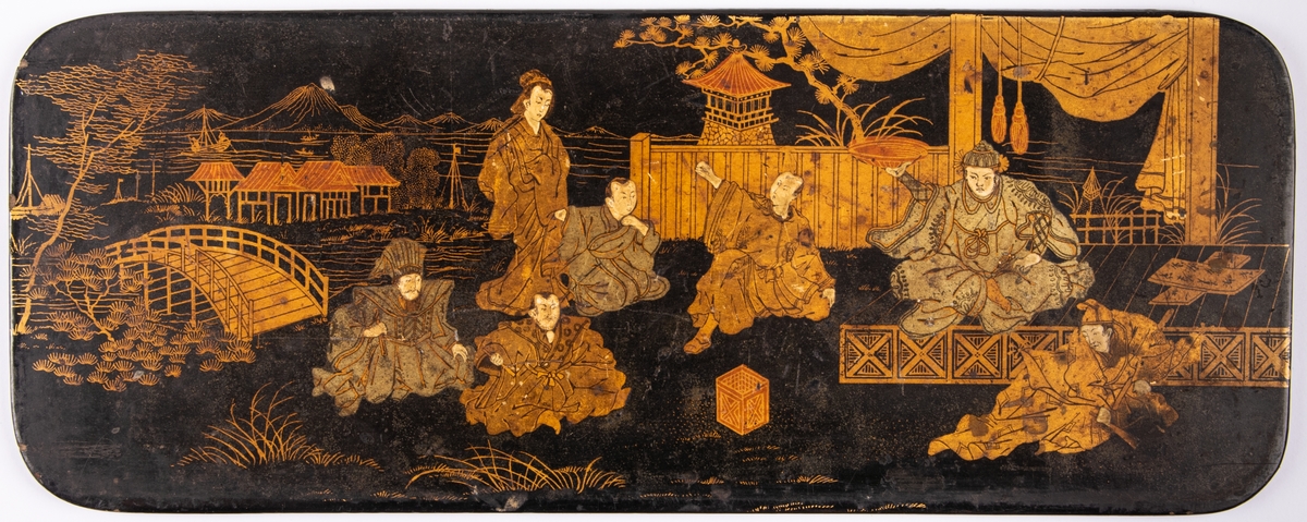 Träbricka, svartlackerad med figurer i guld och silver. Japansk, rektangulär, långsträckt.