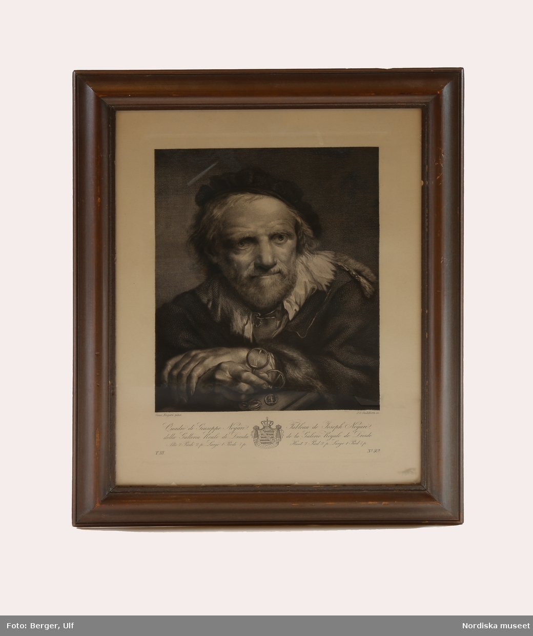 Porträtt, bröstbild en face, av en äldre man som håller i en pincené.