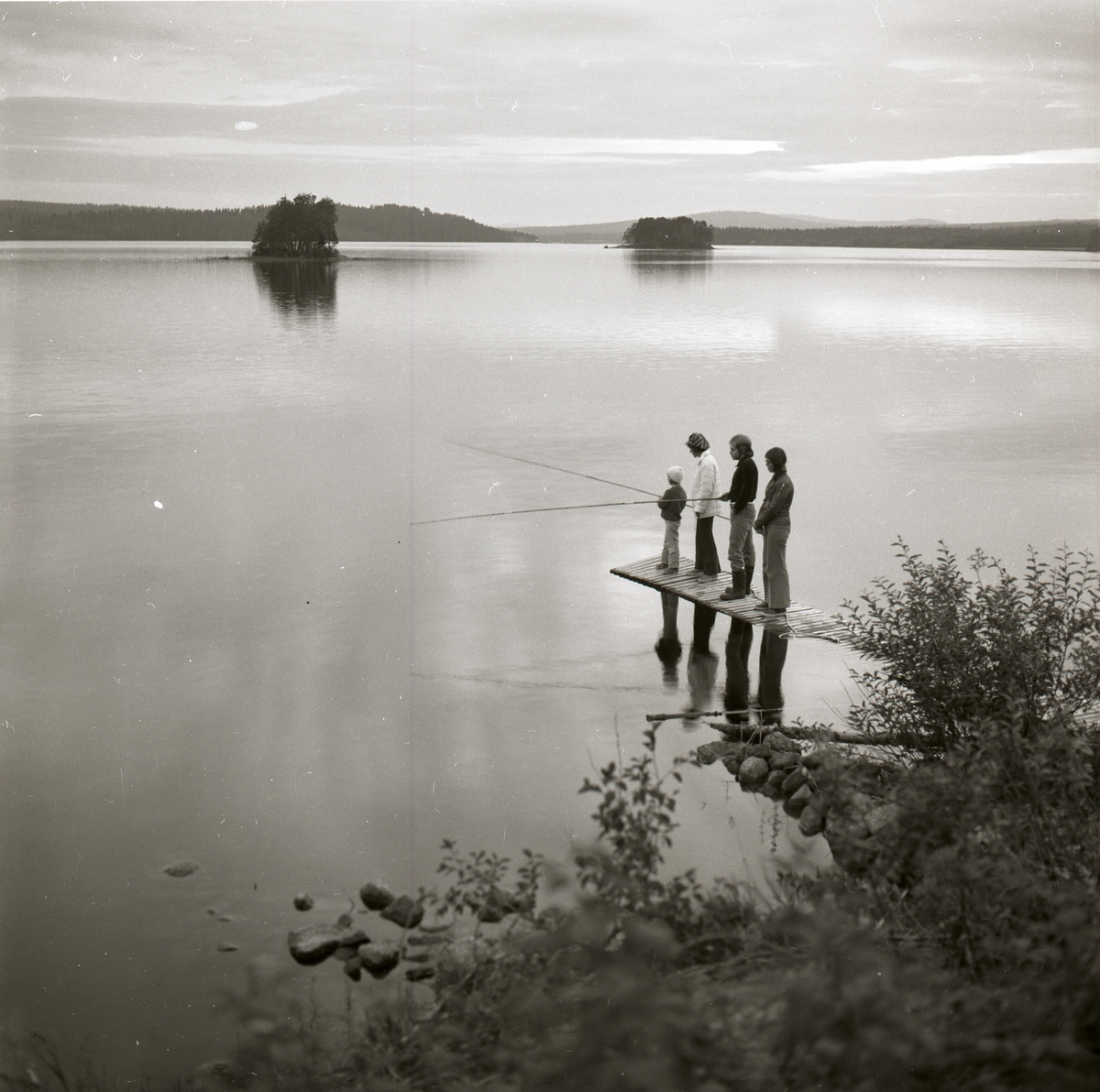 Fyra personer står och fiskar vid Ledingsjön i Björna 1974.