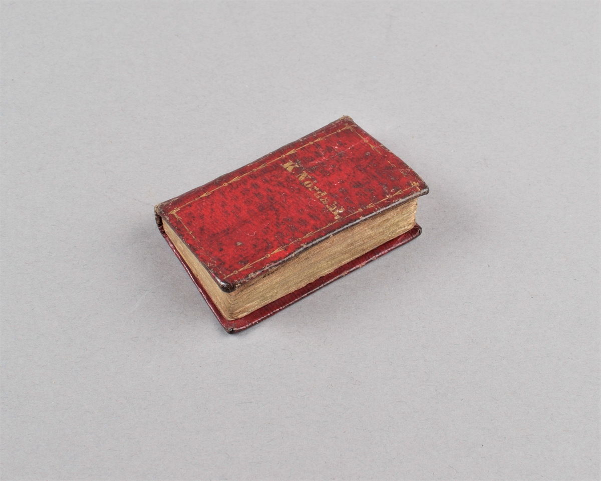 Miniatyrbok innbundet i rødt lær, med preget gulldekor. Tittel: Morgen- og aftenoffer til hver Dag i Ugen