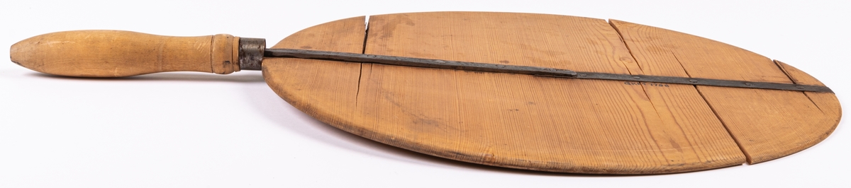 Brödspade av furu, rund med förstärkning tvärs över av järn, svarvat handtag i kanten.
