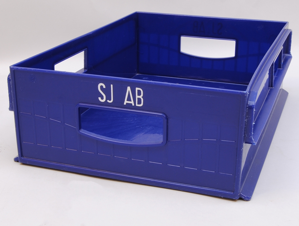 Förvaringslåda, så kallad te-modul (:1) av genomskinligt plexiglas med sju fack i olika storlek för förvaring. Modulen ligger i en blå plastback (:2). Plastbacken har fyra hål, ett på varje sida, som ska fungera som handtag. På båda kortsidorna står "SJ AB" tryckt i vitt.