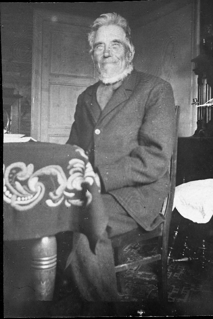 Sven E. Tjensvoll (1842 - 1933) "Blåse-Sven" i stova på Tjensvoll. Han hadde gnr 54, bnr. 11 på Tunheim. Namnet "Blåse-Sven" fekk han avdi han hadde sterkt underbitt og heile tida gjekk og bles.