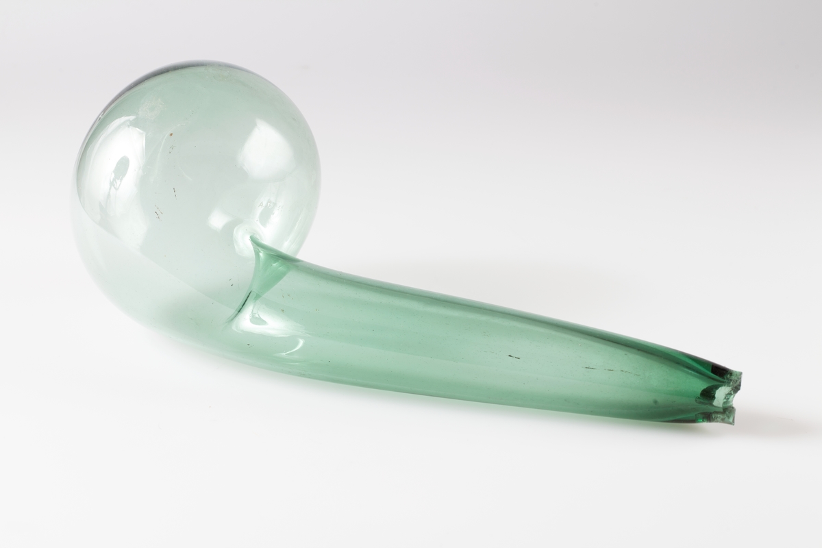 Tubulert retorte av gjennomsiktig grønnlig glass.