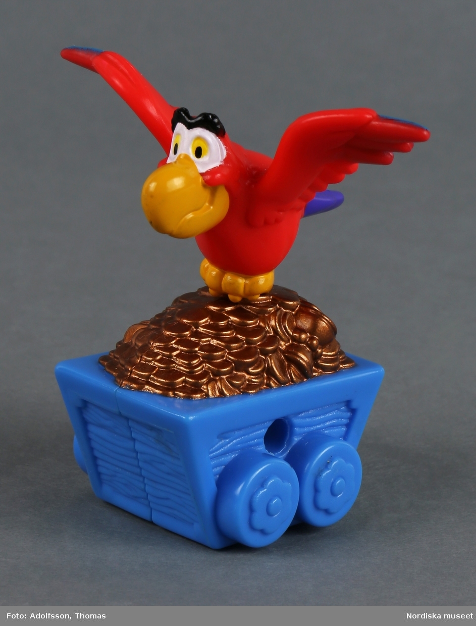Leksak som föreställer papegojan Jago med utbredda vingar. Han vakar över en blå vagn fylld med guldmynt. Fågeln tillhör den maktlystne storvisiren Jafar som är motståndare till berättelsens hjälte Aladdin. På undersidan av vagnen finns fyra hjul.