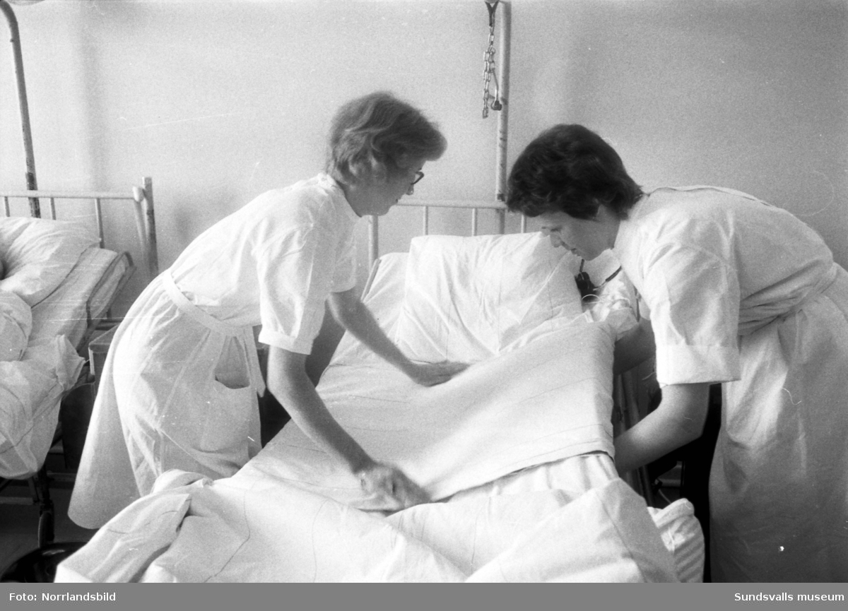 Reportage i Dagbladet 1961 från Sundsvalls lasarett, kirurgavdelningen. Reportern Catja på tidningen praktiserar som sjukvårdsbiträde och vägleds av biträdet Birgitta Modin.