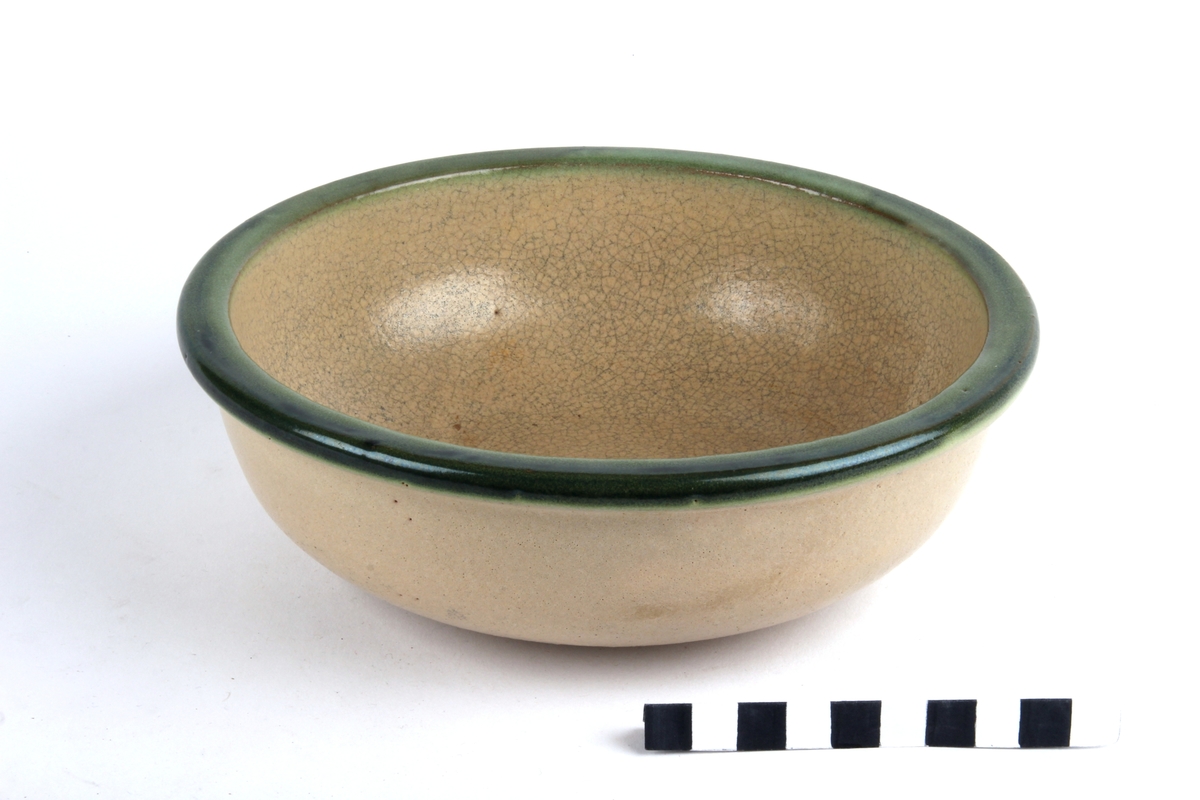 Glasert keramikkskål med grønn kant.