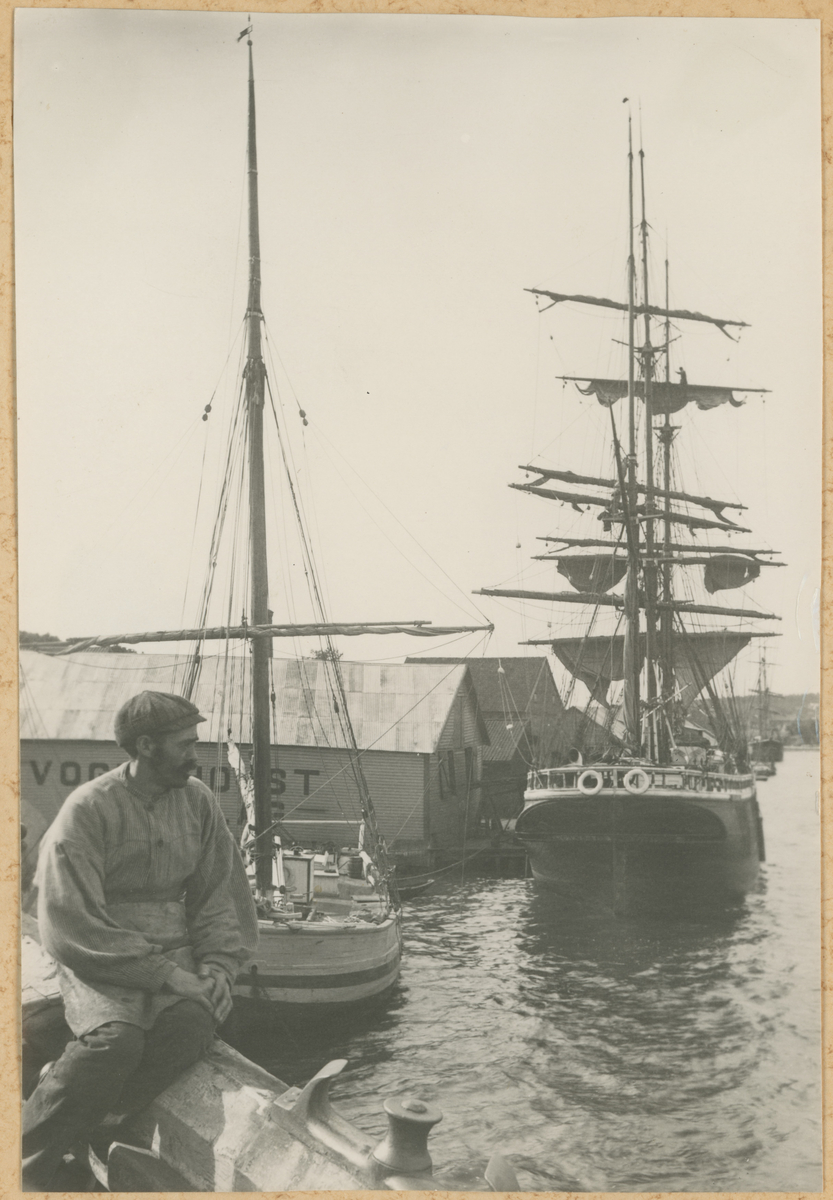Mossesundet. Ca. 1910. Tre kopier av samme bilde. Trykk på pilen for neste bilde.

Fotograf har stått i en båt ved brygga.
Detaljer:	Ukjent sjømann, Vogt & Holst brygga, seilbåt, bark Candaoe.
