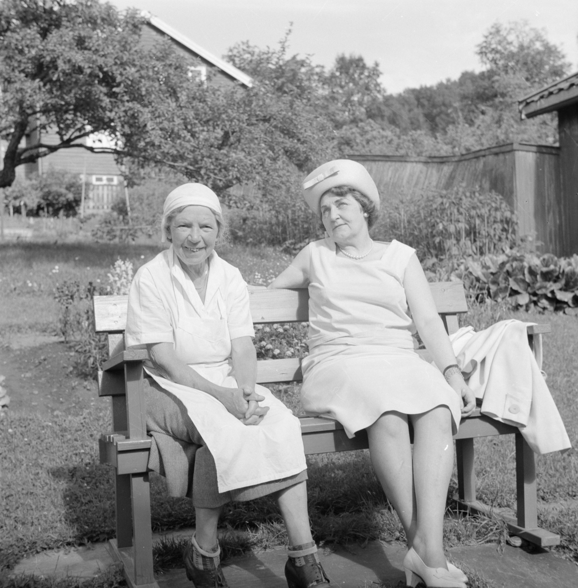 Portrett av to kvinner på en hagebenk i Lillehammer