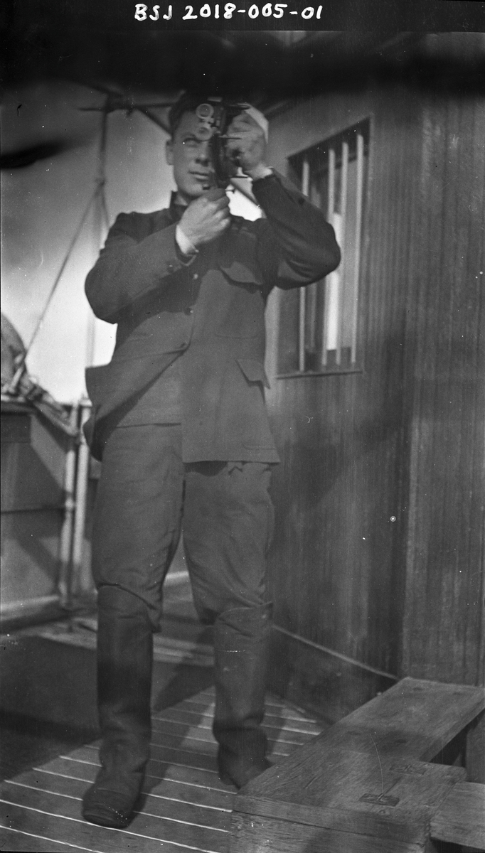 Styrmann Ferdinand Waage ved styrhuset, han tar ut kurs med en sekstant.