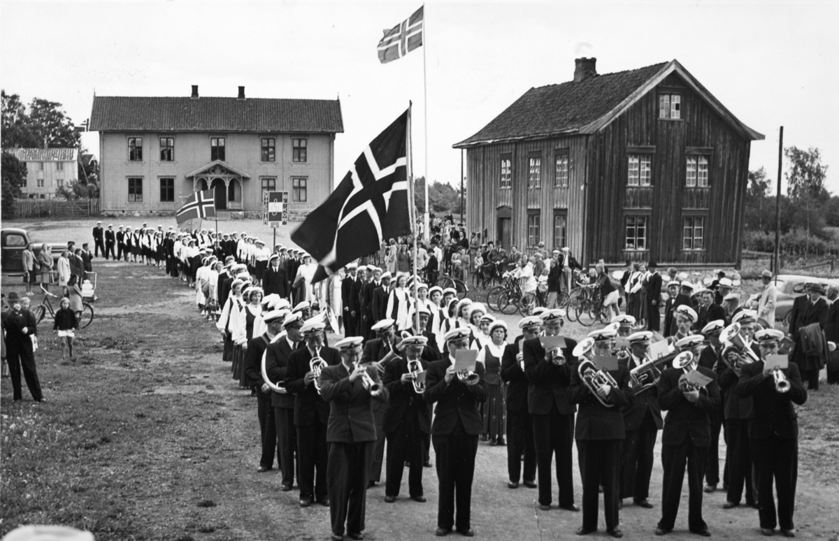 Vang Musikkforening, korsangere, defilering, norske flagg, Kirkekretsen skole, Ridabu skole, Vang kommunehus til høyre,