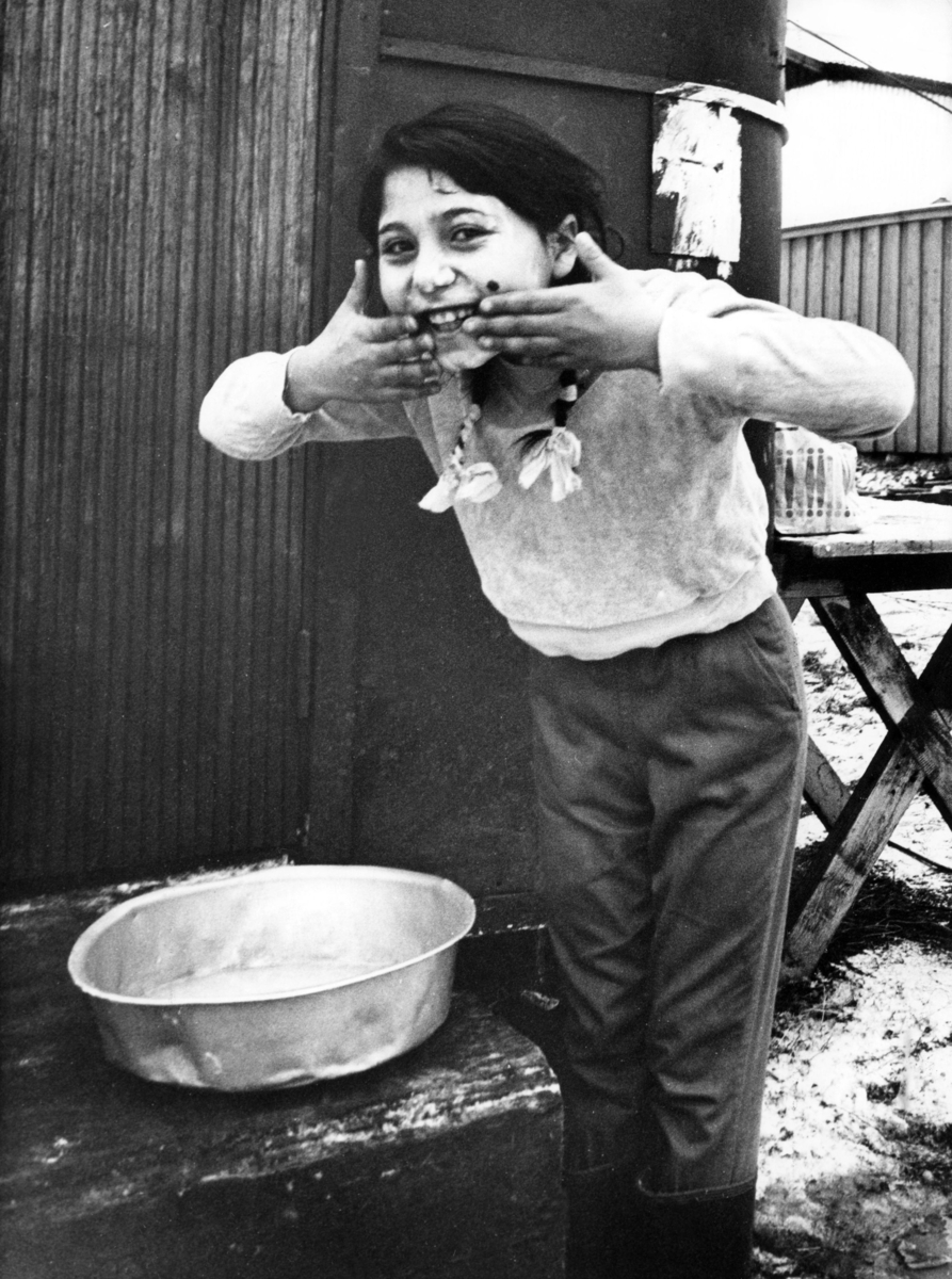 Romsk flicka tvättar sig i ett läger i Alvesta en vinterdag 1964. Ända fram till 1960-talet levde de flesta romer i Sverige under påtvingat kringresande och saknade fast bostad. Romska familjer bodde i tält eller vagnar och flyttade från plats till plats.