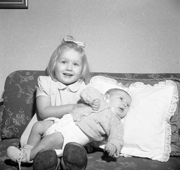 Barn (2) på en soffa.