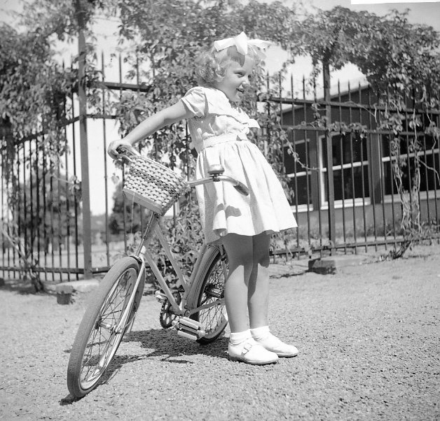 Barn (flicka) med cykel vid underofficersbyggnaden.