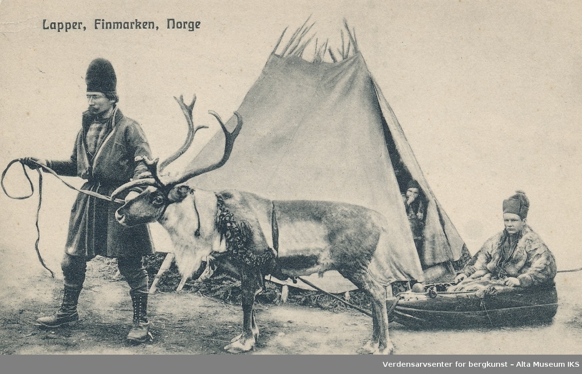 En samisk mann leier et reinsdyr som trekker på en person. Bak dem står en lavvo med et barn som titter ut i åpningen. En rein står bundet bak personen i kjelke.