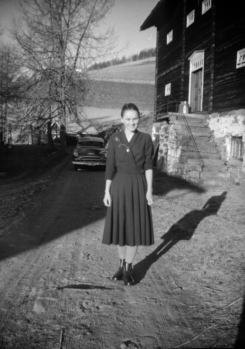 Ung kvinne står ved stabburet på Myklebø, Svatsum