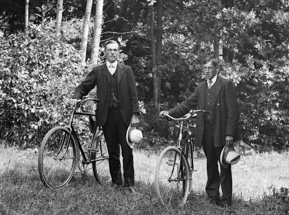 Två vänner på cykelutflykt i Sankt Anna socken. Sannolikt har männen stannat till vid fotograf Emil Durlings bostad i Strömmen.

Anm: Männens identiteter har inte kunnat styrkas.