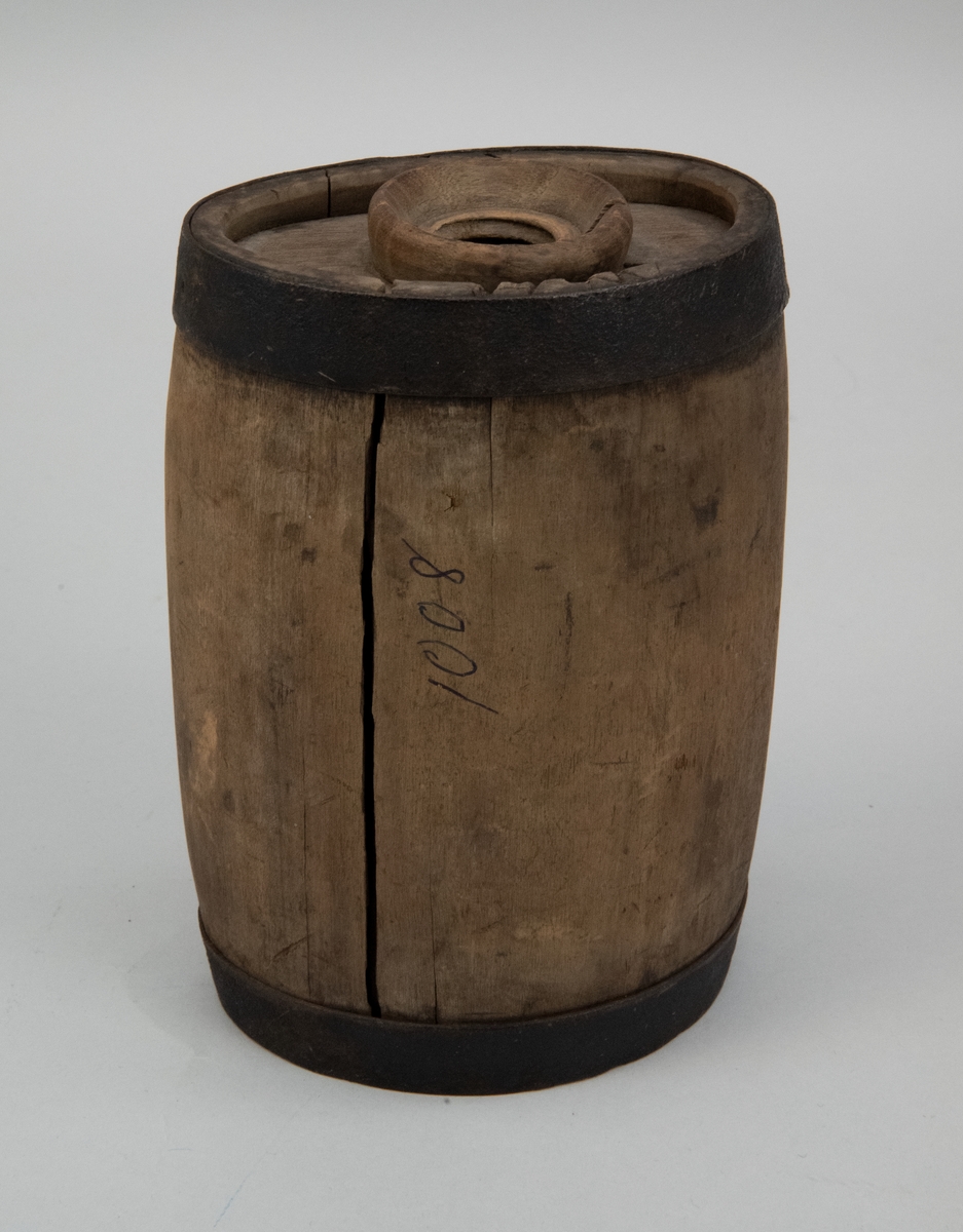 Drickvattenbehållare eller flaska, av gråbrunt trä med förstärkande metallband upptill och nertill.