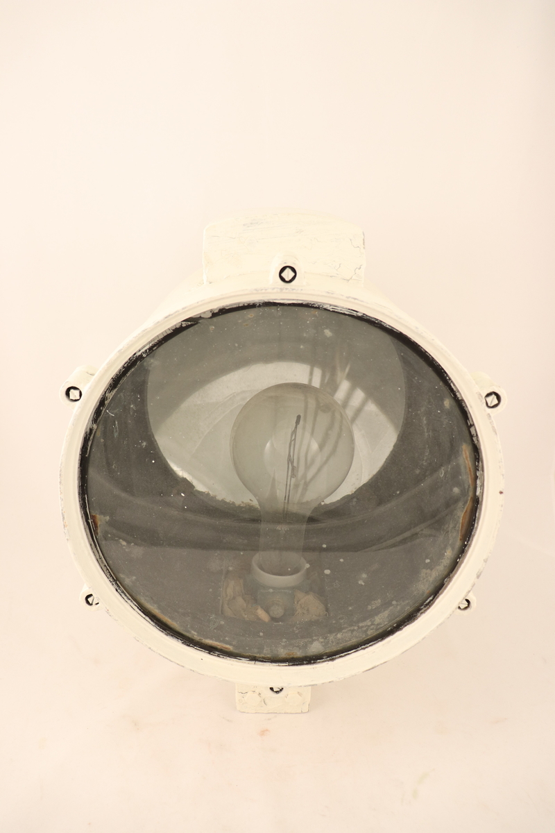 En hvitmalt lyskaster som er brukt om bord i et skip.