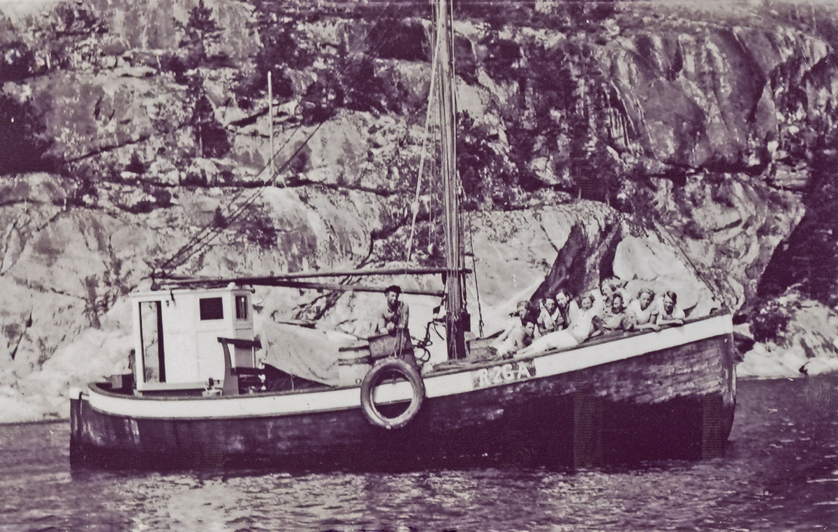 En gjeng fra Sevland på båttur i fjordene. Et av mannskapet slapper av midtskips. Passasjerene, de fleste kvinner, slapper av på framdekket.