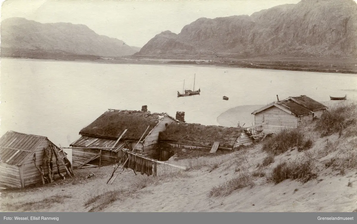 Rorbuer ved elvemunningen på norsk side i Grense Jakobselv ca 1903-1905. Utsikt oppover dalen. Fjellene til venstre ligger i Russland.