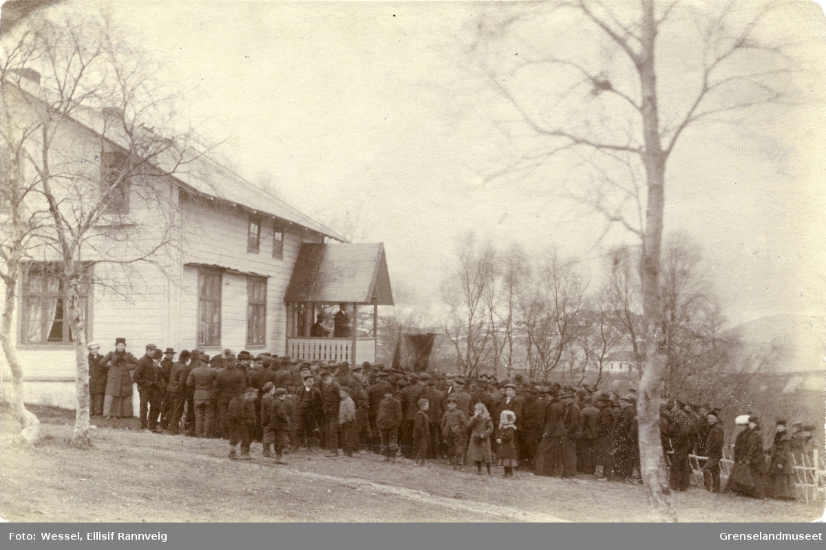 Streikende samlet utenfor doktorgården Solheim samlet til streik. Nordens klippes første streik 24. mai 1908. Sekretær i Arbeidsmandsforbundet Johan Karlgren og Thorolf Bugge fra Nordens Klippe står på verandaen. Kirken nede på neset, ses i bakgrunnen.
