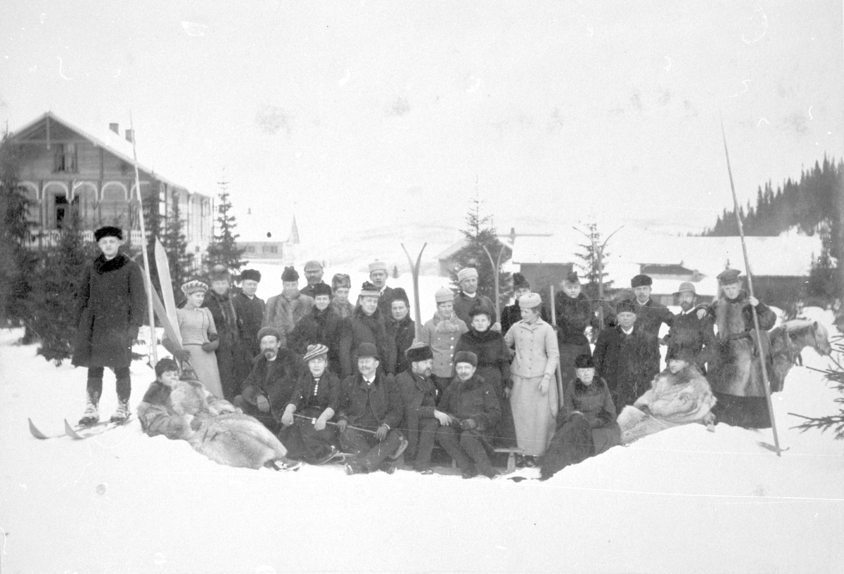 Ei gruppe mennesker med skiutstyr er avbilda foran Tonsåsen sanatorium i Etnedal.