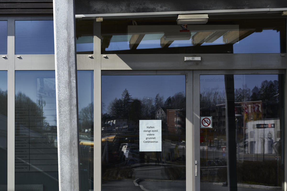 Koronaskilt på dørparti ved Gjønnes Idrettshall under koronanedstengningen