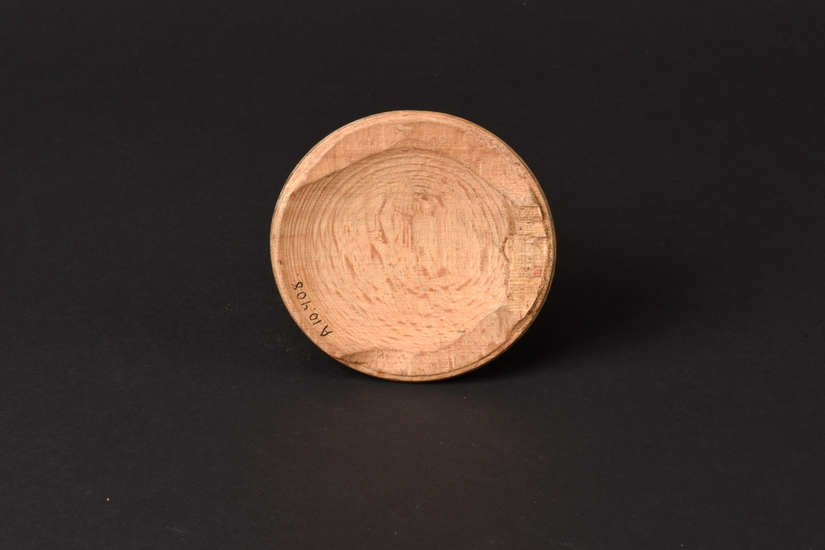 Rund svarvad smörask med lock, tillverkad av ek. Locket har en rektangulärt utskuren knopp som handtag.
