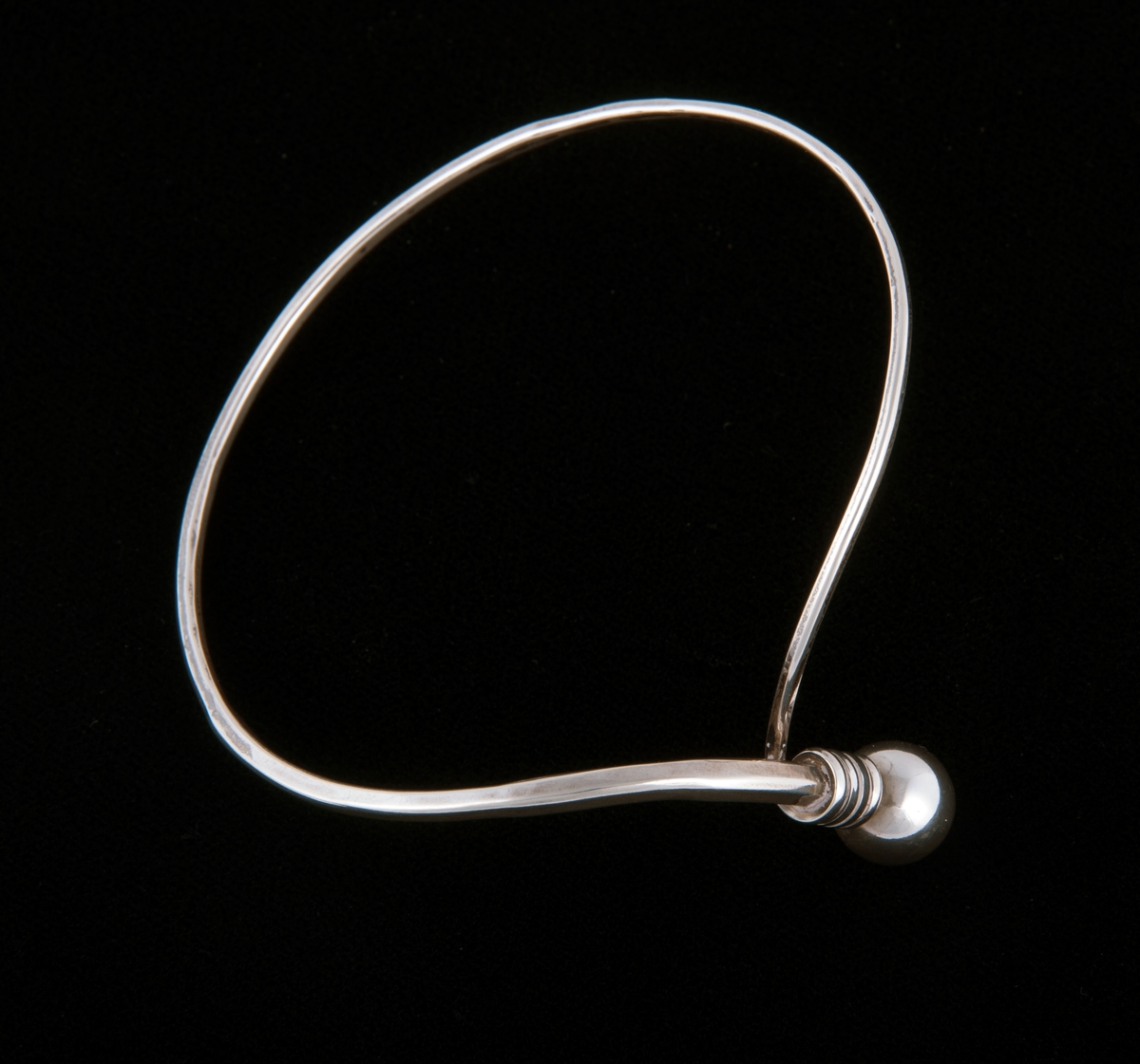 Består av en sølvtråd som avtar i bredde fra ende til annen. Endene forenes til en ring som markeres med en sølvkule. Kulen og endene er bøyd ut i vinkel fra armringen. 