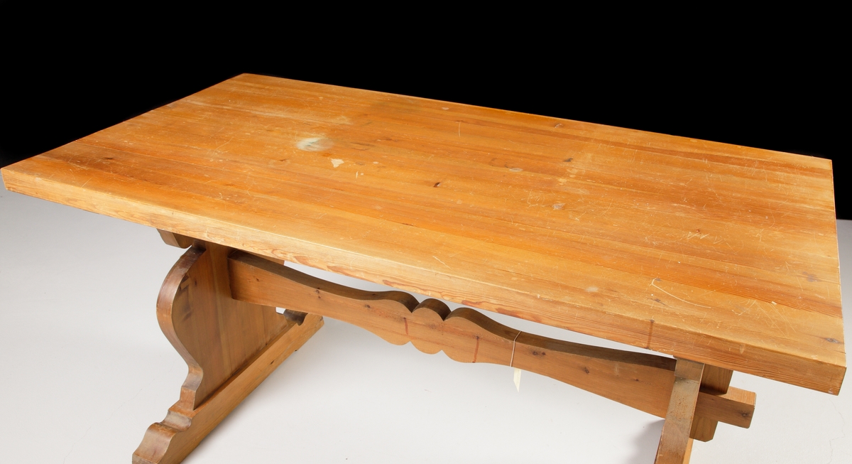 Ett större bord av furu i s.k. allmogestil. Profilerade ben med mittslå. Bordet har använts som skrivbord.