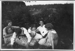 Ungdommer morer seg i gresset. Trolig 1930-tall.