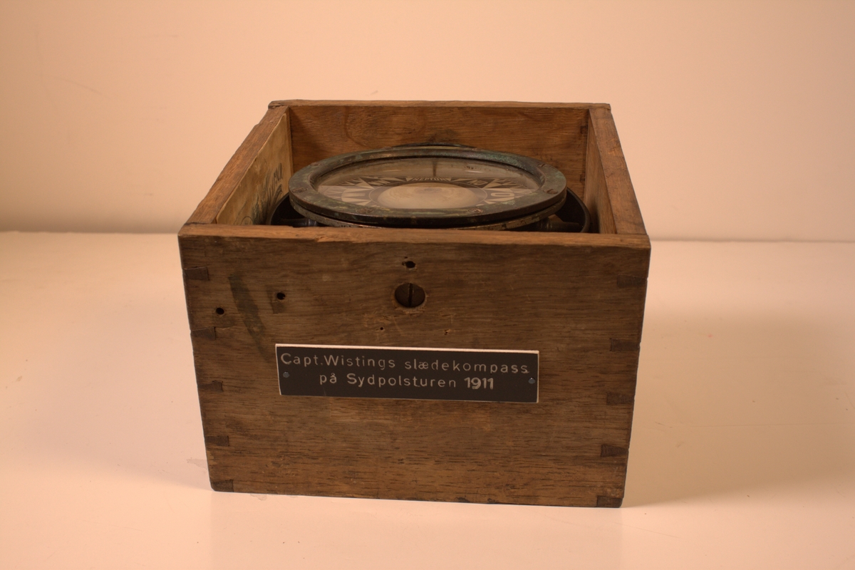 Kompasset er merket "Neptun". Rosa har en hvit bunn med svarte symboler. Kompasset skal være i en kasse med et skilt som sier "2838. Capt Wistings slædekompass på Sydpolen 1911".
