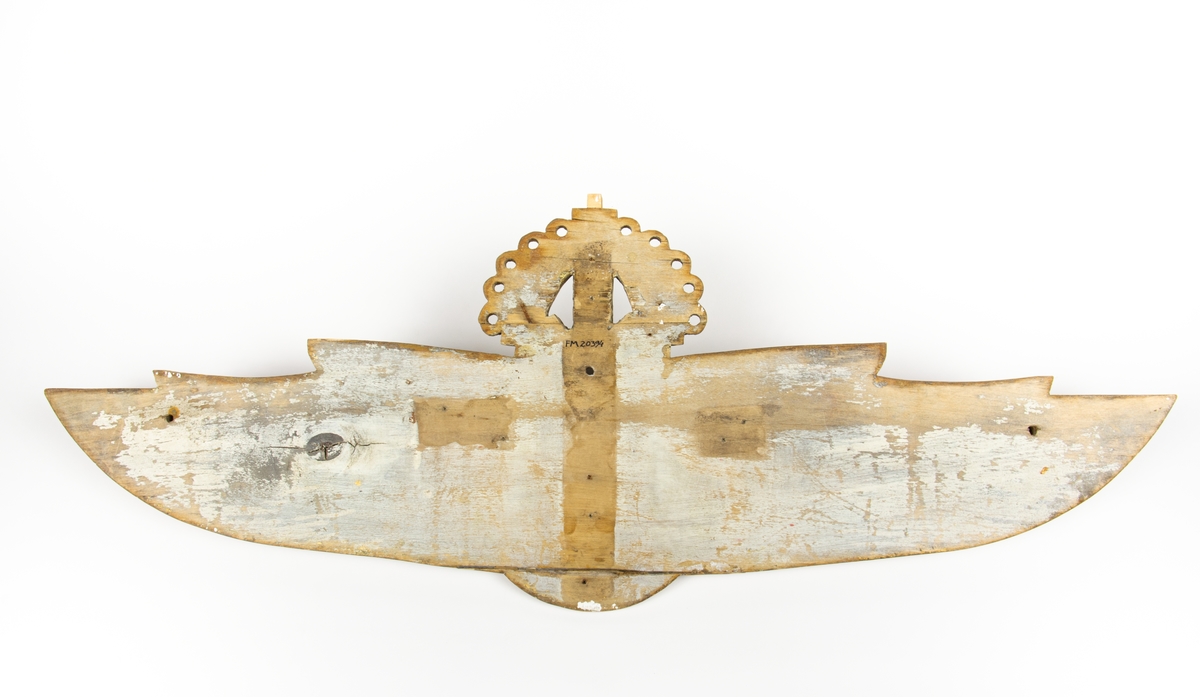 Flygvapenemblem m/26. Bemålad och förgyld relief av trä i form av en flygarvinge.