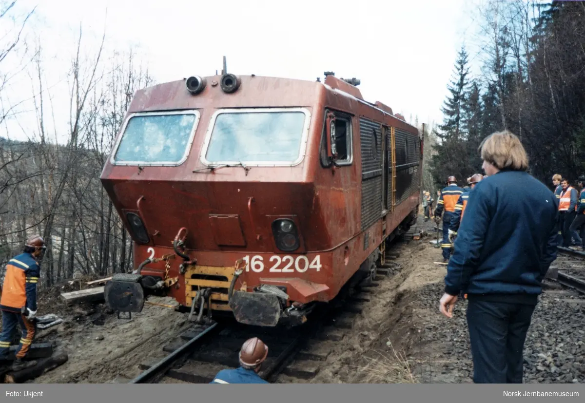 Avsporet og veltet elektrisk lokomotiv El 16 2204 etter å å kjørt inn i et jordras. Lokomotivet fikk store skader, men ble berget og reparert. Her trekkes lokomotivet opp på hovedsporet av diesellokomotiv Di 3 626