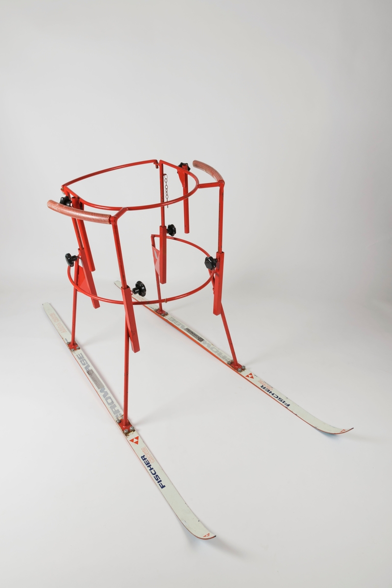 Består av et metallstativ montert på et par ski. Fire skruer/bolter holder hvert av de fire stativbeina fast. Stativet kan reguleres ved hjelp av seks svarte skruknotter. Bakre bøyle/stang på stativet kan løftes av. En kort kjetting henger til venstre for bøylen og har trolig vært festet til den. Håndtakene er polstret med hard gummi.