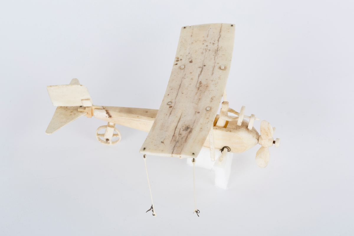 Modellfly i hvit ben. A)flykroppen B) vingen med en brukket stag C)Mann