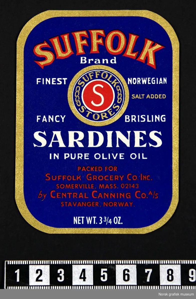 Blå etikett med detaljer i gull, rødt og hvitt. Midt på er en logo for "Suffolk stores"

"Fancy brisling sardines in pure olive oil"