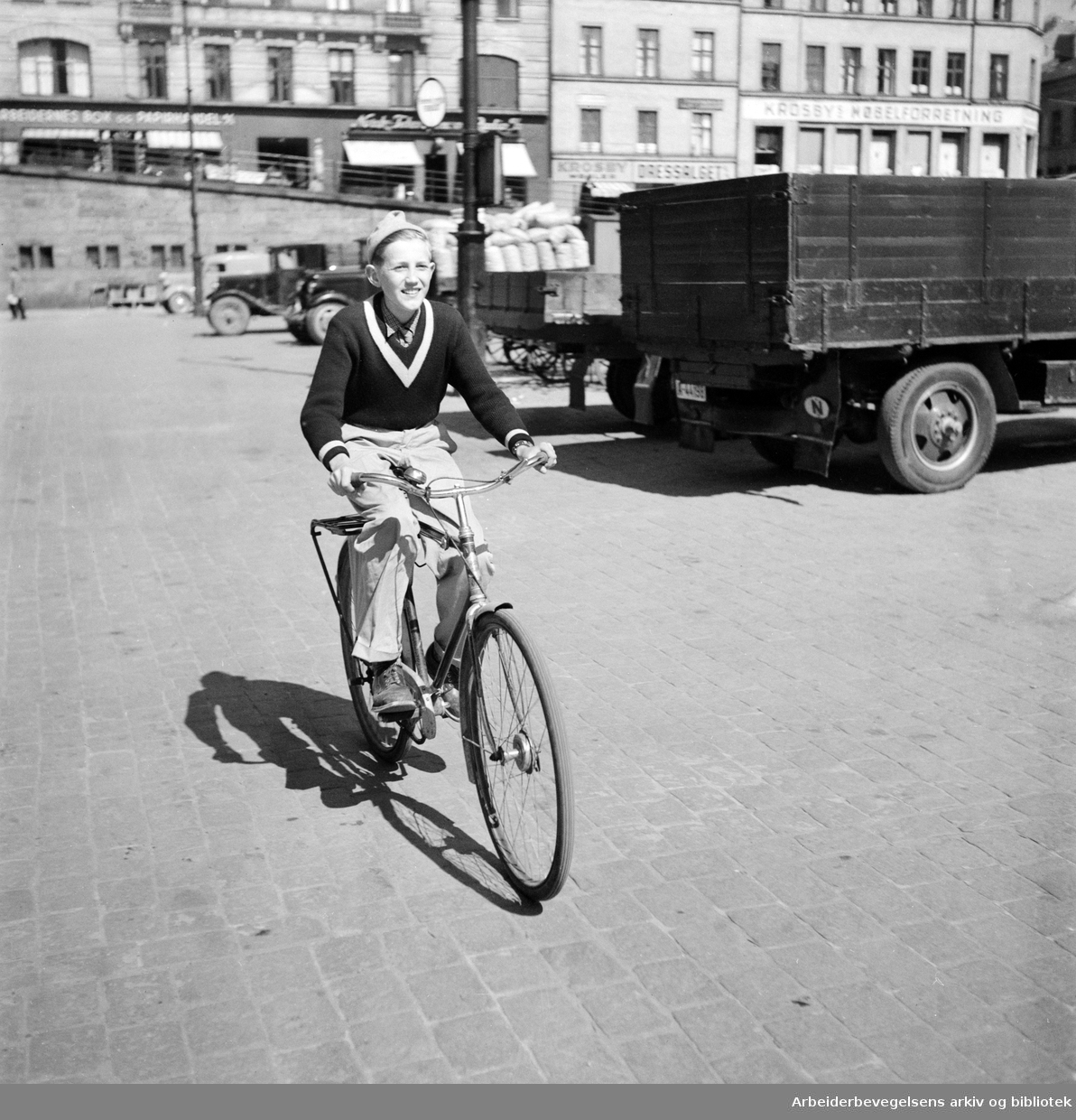 Visergutt på sykkel. Ukjent. Youngstorget. Mai 1952.