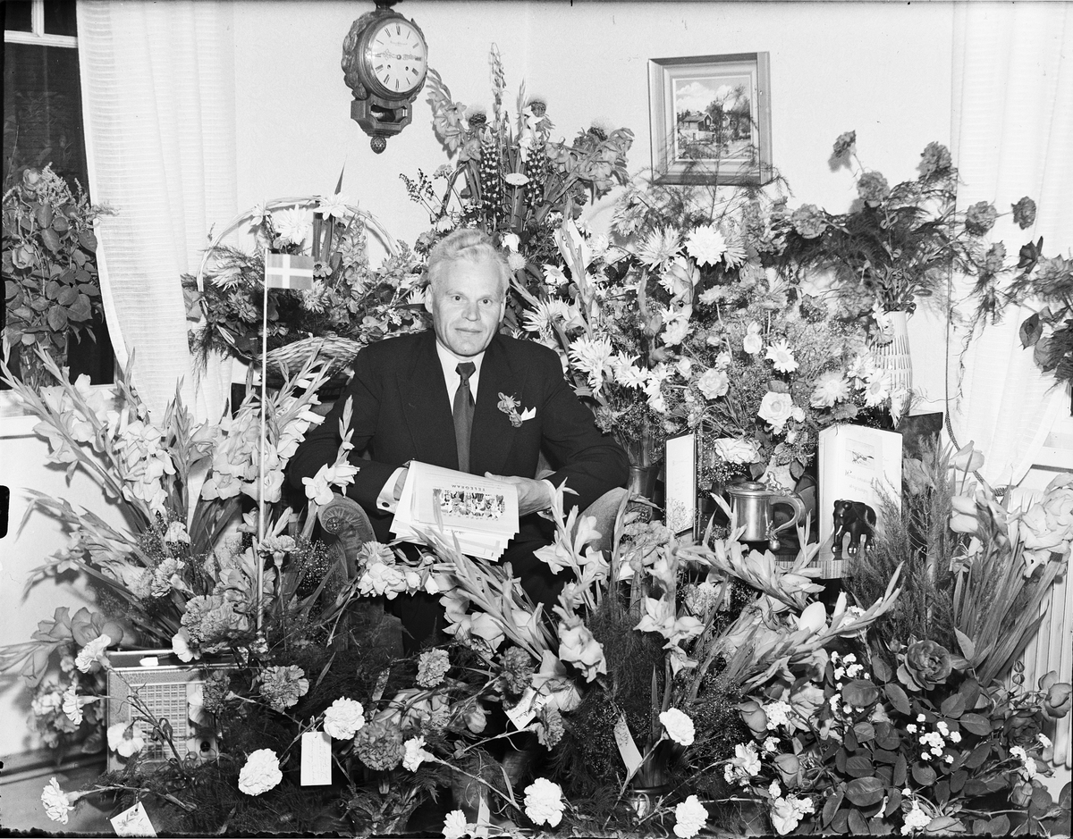 Man i hemmiljö omgiven av blommor firar 50-årsdagen, Östhammar, Uppland