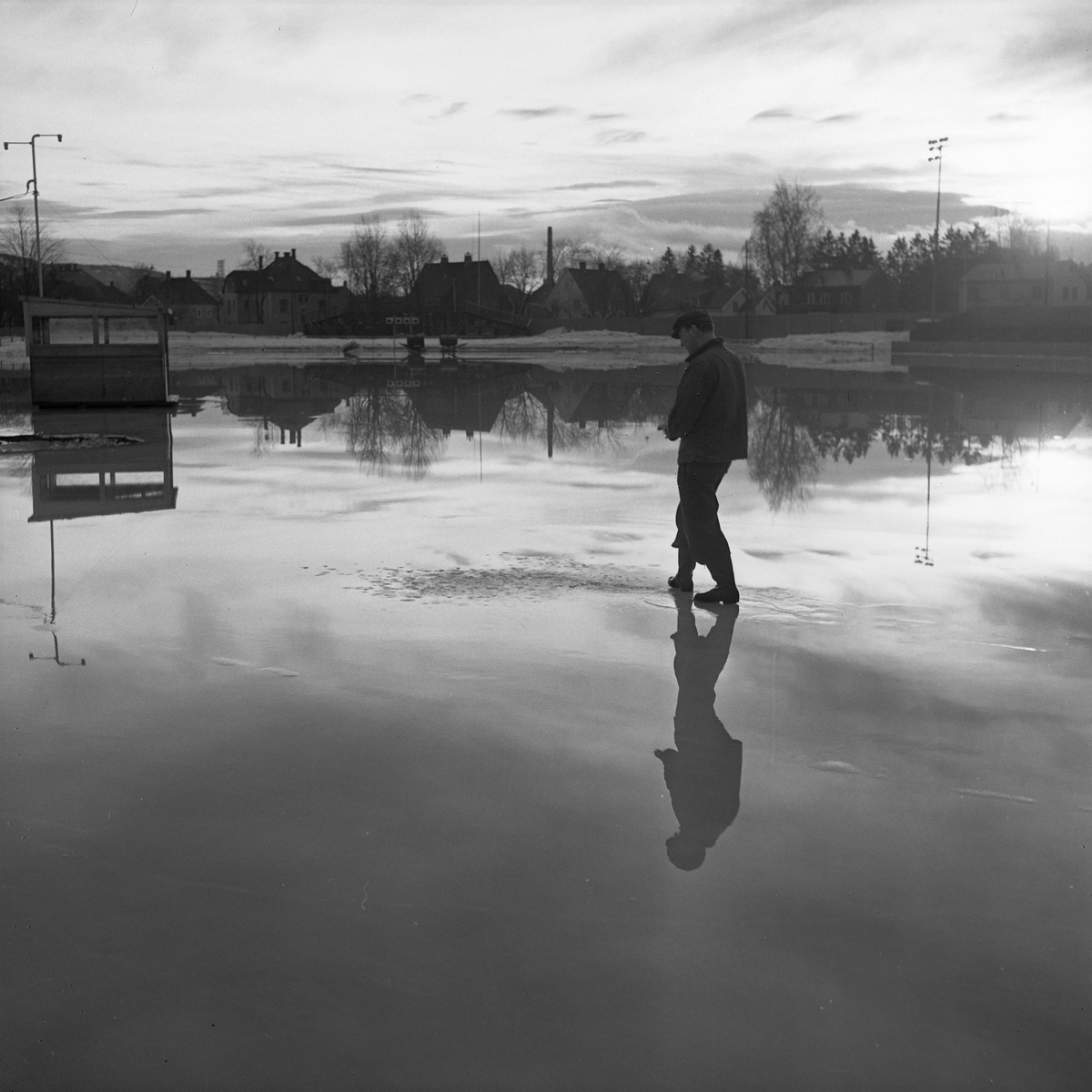 Oversvømmelse på Stadion foran landskampen. Banemester Thingstad studerer forholdene