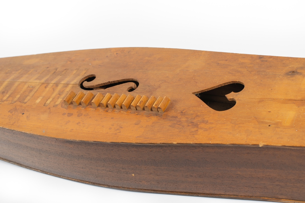 Utbuktende kropp med konvekse sidestykker. Skruekasse med rett brett i forlenging av kroppen. Seks stemmeskruer (gitar/mandolin-skruer) av metall. Tverrbjelke under lokket, synlig gjennom lydhull. Enkelt f-lydhull og et hjerteformet lydhull. 15 tverrband (mangler). 13 noter ved siden av f-lydhull. D-dur. Notesadel oppe og nede (mangler). Strenger (mangler): 1 melodi, 5 bodun. Vurdert strengefeste, ni hakk på notesadel nær stemmeskruene, fem på nedre ende. Fire metallfester på nedre endevegg. Ben oppe og nede (mangler). 
Lite eller ingen bruksmerker/slitasje etter spill.