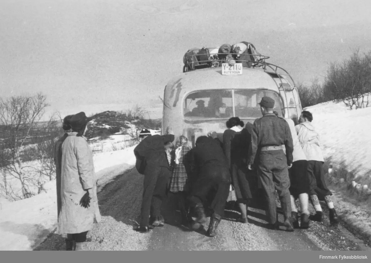 Polarbil-buss med problemer, passasjerene skyver på. Stedet er i nærheten av Skiippagurra, tidspunktet påsken 1956.