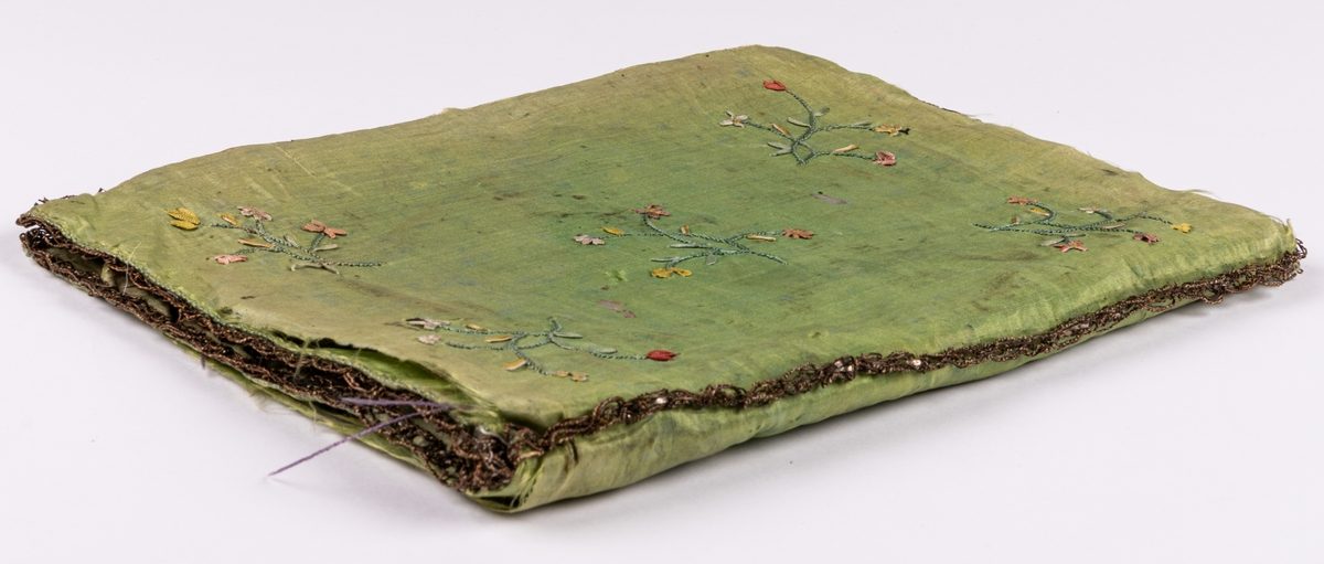 Plånbok i grönt siden, fodrad med rosa siden. Broderad med silke och smala band. Märkt 1782.