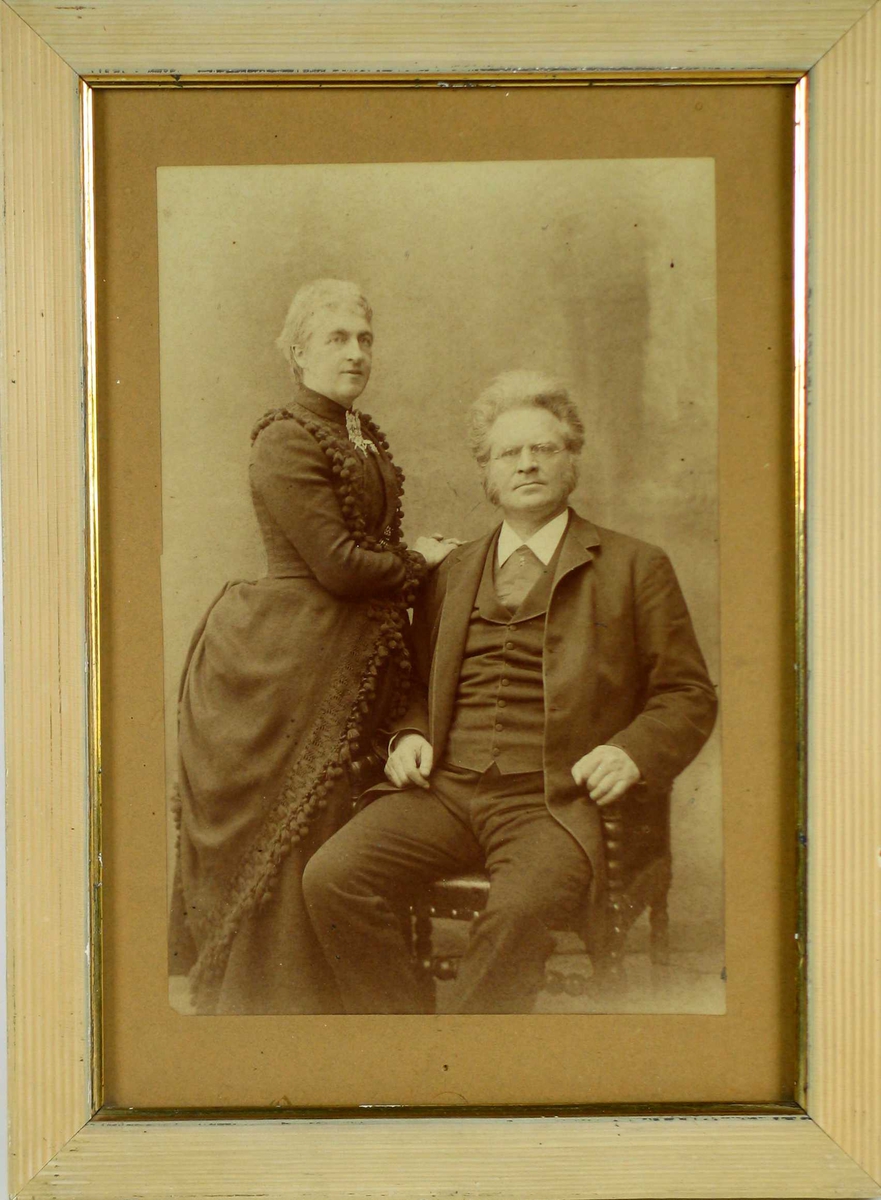 Fotografi limt på grå kartong med hvit rillet treramme og gullkant.