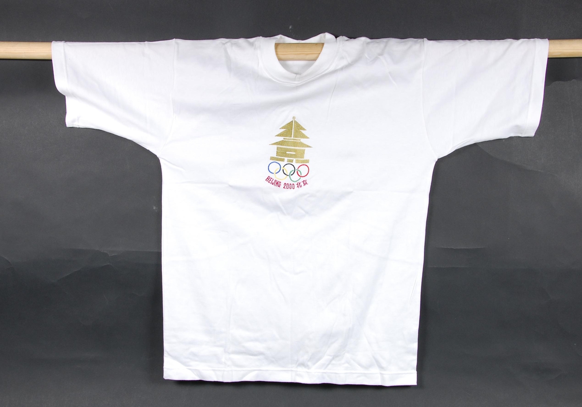 Hvit t-skjorte med flerfarget logo for kandidatbyen Beijing i forbindelse med søkerprosessen til de olympiske leker i 2000. 